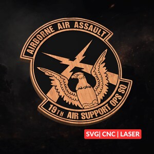 Könnte beinhalten: Holzemblem mit den Texten "AIRBORNE AIR ASSAULT" und "19TH AIR SUPPORT OPS SQ", die ein zentrales Design umgeben. Das Design zeigt einen Adler mit ausgebreiteten Flügeln und Blitzen. Das Emblem ist aus Holz gefertigt und trägt den Text "SVG | CNC | LASER".