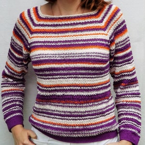 Pu&ograve; includere: Un maglione in maglia a maniche lunghe caratterizzato da un motivo a righe orizzontali nei toni del viola, arancione brillante e bianco sporco. Il capo presenta un ampio scollo rotondo e polsini e orlo a coste con lavorazione testurizzata.