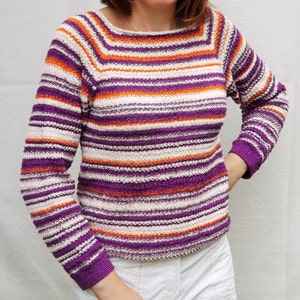 Pu&ograve; includere: Un maglione in maglia a maniche lunghe con un motivo a righe orizzontali in tonalit&agrave; vivaci di viola, arancione brillante e bianco sporco. Il capo presenta un ampio scollo a barchetta e polsini aderenti, con una lavorazione testurizzata.
