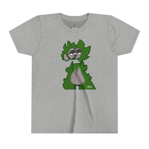 Könnte beinhalten: Hellgraues T-Shirt mit einem Cartoon-Charakter mit grünem Fell und einem grauen Gesicht. Der Charakter hat einen schläfrigen Gesichtsausdruck. Der Text "tkjo" befindet sich unten rechts. Das Shirt hat einen Rundhalsausschnitt und kurze Ärmel.