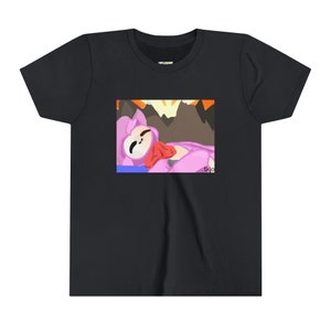 Könnte beinhalten: Schwarzes T-Shirt mit einem Cartoon-Motiv. Die Grafik zeigt eine rosa Figur mit rotem Schal und weißem Gesicht, die vor einer Bergkulisse liegt. Der Text "tkjo" ist unten rechts im Bild zu sehen.