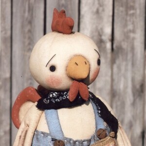 May include: A white chicken doll wearing blue overalls, a red bandana, and a brown bag that says "Rooster Brand Coffee". The doll is holding a red and white can that says "Rise & Shine" with a yellow sun on it.