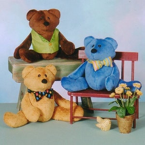 May include: Three plush teddy bears, one brown, one blue, and one tan, are sitting on a wooden bench and a small red chair. The brown bear is wearing a green vest, the blue bear is wearing a striped scarf, and the tan bear is wearing a colorful bow tie.