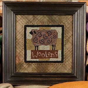 May include: A framed needlepoint design featuring a brown sheep with the word "Woolens" in a banner below. The background is a tan and brown fabric with a stitched border.
