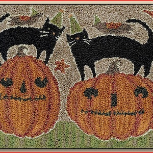 May include: Two black cats with party hats stand on top of orange pumpkins with carved faces. The pumpkins are on a brown background with green grass.