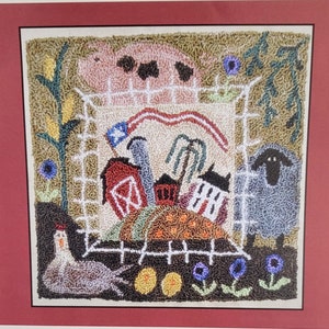 May include: A colorful needlepoint design featuring a farmhouse scene with a red barn, a white house, a pig, a sheep, a chicken, and a waving American flag.