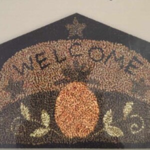 May include: A black and brown welcome sign with a gold maple leaf on top. The sign has the word "WELCOME" in gold letters and a brown circle with gold leaves on either side.
