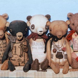 May include: Five handmade plush teddy bears with different fabric patterns and embroidered details. The bears are sitting on a patterned fabric surface. The bears are wearing various accessories, including a pocket watch, a necklace, and a cane sugar bag.
