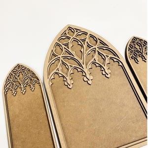 May include: Three light brown wooden panels featuring intricate laser-cut arched tops with detailed tracery patterns. The panels have a smooth, flat surface below the decorative upper sections, showcasing a natural wood grain texture throughout.