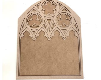 May include: A wooden cutout of a gothic archway with intricate details. The archway is made of a light brown wood and has a blank space in the center.