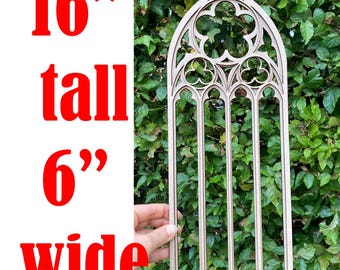 Puede incluir: Un marco de ventana gótica de madera marrón claro, de 40,6 cm de alto y 15,2 cm de ancho. El marco presenta una parte superior arqueada con intrincados diseños recortados y barras verticales. El texto "16" tall 6" wide" se muestra en rojo.