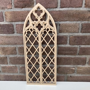 Può includere: Un ritaglio in legno di una finestra ad arco gotico con un motivo a rombi. La finestra è in legno grezzo ed è pronta per essere dipinta o verniciata.