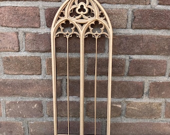 Puede incluir: Un recorte de madera de una ventana de arco gótico con intrincados detalles. La ventana está hecha de múltiples piezas de madera que se unen para crear un aspecto realista. La ventana es de color marrón claro y tiene un acabado de madera natural.