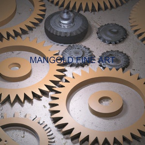 May include: A close-up of a set of gold-colored gears with a white background. The gears are arranged in a circular pattern, with the largest gear in the center. The text "MANGOLD FINE ART" is visible in the center of the image.
