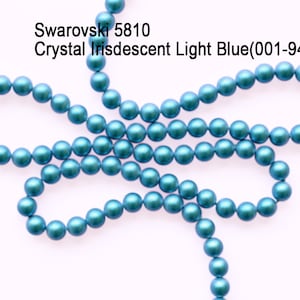 May include: A strand of light blue iridescent Swarovski 5810 crystal beads. The beads are round and have a smooth, shiny finish.