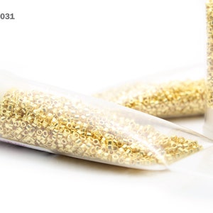 K&ouml;nnte beinhalten: Goldene Saatperlen in einem durchsichtigen Plastikr&ouml;hrchen. Artikel: DB-0031