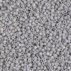 Peut inclure: Gros plan sur un tas de petites perles cylindriques blanc cassé. Chaque perle est percée d'un trou en son centre. Les perles sont densément tassées, remplissant le cadre. La texture générale est lisse et uniforme.