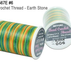 K&ouml;nnte beinhalten: Zwei Spulen Miyuki Bead Crochet Thread. Die Spule links ist ein mehrfarbiger Faden in Gr&uuml;n-, Gelb- und Oranget&ouml;nen. Die Spule rechts ist ein hellgr&uuml;ner, gelber und wei&szlig;er Faden. Das Etikett auf der Spule rechts lautet "Miyuki Bead Crochet Thread 167dtex 2x3 (0,45 mm) 25 m (27 yds) LOT. NJ05R COL. 006"