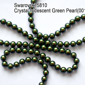 May include: A strand of iridescent green Swarovski crystal pearls. The pearls are 5810 size and have a green iridescent finish. The pearls are arranged in a flower shape.