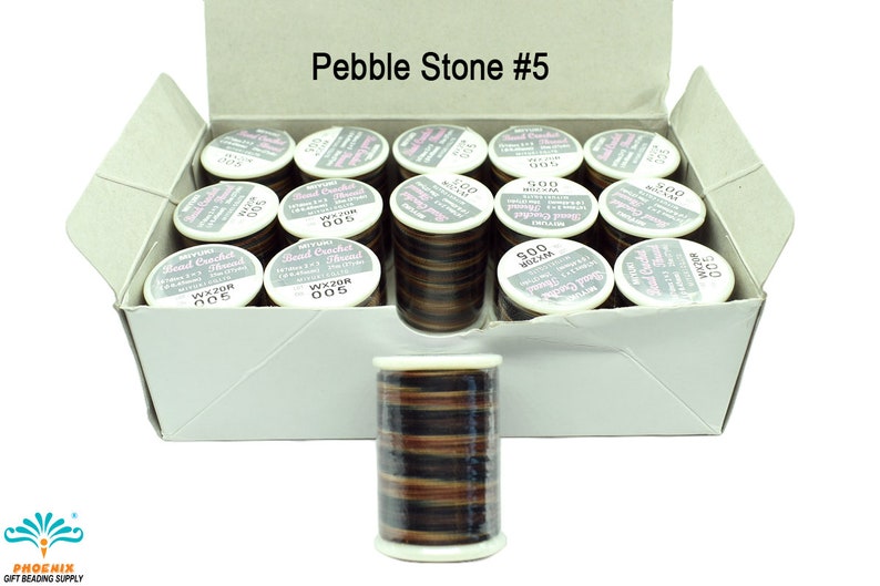 K&ouml;nnte beinhalten: Eine Schachtel mit 20 Spulen braunem, schwarzem und beigefarbenem Perlenh&auml;kelgarn. Die Schachtel ist mit "Pebble Stone #5" beschriftet.