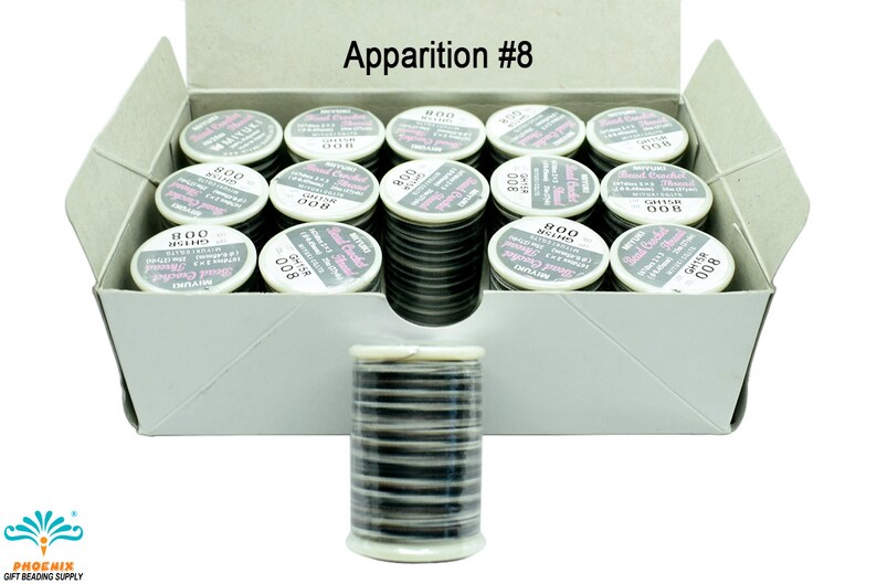 K&ouml;nnte beinhalten: Eine Schachtel mit 24 Spulen schwarzem Perlen-H&auml;kelgarn, beschriftet "Miyuki Bead Crochet Thread 800 008". Die Schachtel ist mit "Apparition #8" beschriftet.