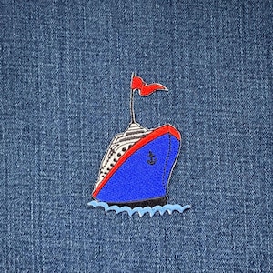 May include: An embroidered patch featuring a cruise ship with a blue hull, red trim, and a white superstructure, set against a blue denim backdrop. The ship has a red flag and is depicted sailing on blue waves. The patch is a vibrant nautical design.
