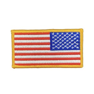May include: A rectangular embroidered patch featuring the United States flag design. The patch displays horizontal red and white stripes with a blue canton containing white stars, all bordered by a thick, solid yellow stitched edge.