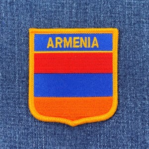 May include: An embroidered patch featuring the colours of the Armenian flag, with the word "ARMENIA" in yellow lettering.