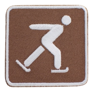 May include: Brown square patch with white stitching around the edges. A white silhouette of a person ice skating is in the center of the patch.