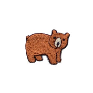 May include: Embroidered patch of a brown bear with a white face and black eyes. The bear is standing on all fours, with its paws and body outlined in a darker brown. The patch is likely for clothing or accessories.
