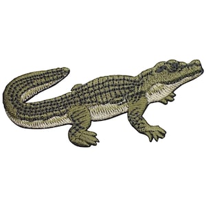 May include: Embroidered patch featuring a detailed alligator design. The patch showcases a green and black color scheme, with intricate stitching that highlights the alligator's scales and form. The patch is designed to be ironed or sewn onto fabric.