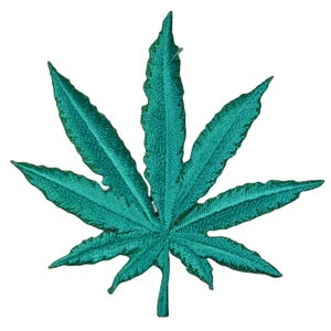 May include: Embroidered patch in the shape of a cannabis leaf. The patch is teal green with detailed stitching, showcasing the leaf's veins and edges. The design is a stylized representation of a marijuana leaf.