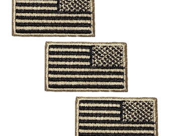 May include: Three embroidered American flag patches in a camouflage pattern. The patches are beige with black stripes and a black camouflage pattern in the canton.