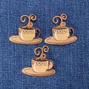 May include: Three embroidered iron-on patches of coffee cups with steam rising from the top. The cups are brown with a white interior and a brown saucer. The patches are perfect for adding a touch of whimsy to clothing, bags, or other fabric items.