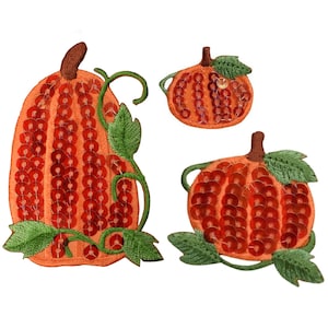 May include: Three orange pumpkin patches with green leaves and red sequins. The pumpkins are different sizes and are perfect for adding a festive touch to your crafts.