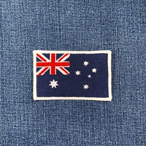 May include: A rectangular patch featuring the Australian flag, with a dark blue background and a white border. The flag design includes the Union Jack in the upper left corner, the Southern Cross constellation, and a large Commonwealth Star.