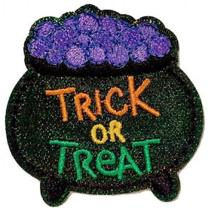 May include: A green cauldron with a purple cauldron full of candy on top. The cauldron has the text "Trick or Treat" in orange, yellow, and green.