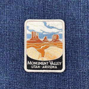 May include: A rectangular patch featuring a landscape of Monument Valley in Utah and Arizona. The design includes orange rock formations, tan desert terrain, blue sky, and white clouds. The text "MONUMENT VALLEY UTAH - ARIZONA" is printed in white on a black background.