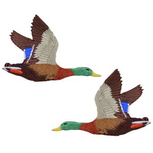 May include: Two brown and white mallard ducks in flight with blue and green accents. The ducks are embroidered and are perfect for adding a touch of nature to your crafts.