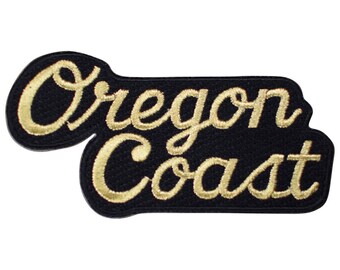May include: Gold embroidered patch with the text "Oregon Coast" on a black background.