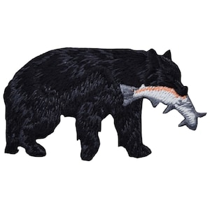 May include: Black bear silhouette with a fish in its mouth. The bear is walking to the right and the fish is white with orange accents.