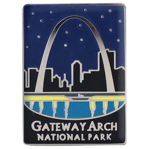 Puede incluir: Pin rectangular con el Gateway Arch contra un cielo azul oscuro estrellado. El arco es plateado y el horizonte es negro. Las palabras "Gateway Arch National Park" están en la parte inferior.