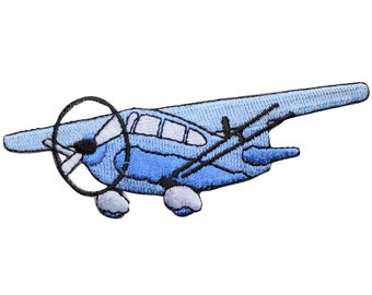 以下が含まれることがあります： 黒いプロペラとアクセントが付いた、水色の飛行機の刺繍パッチ。このパッチは、衣類やアクセサリーに追加するのに最適な、ヴィンテージ航空機の詳細なデザインが特徴です。このパッチは、アイテムをパーソナライズするための楽しくてユニークな方法です。