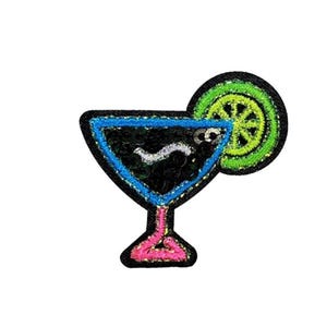May include: An embroidered patch shaped like a martini glass with a black sequined interior, a bright blue border, and a pink stem. A lime slice in vibrant neon green is attached to the rim, featuring a black stitched wheel pattern.