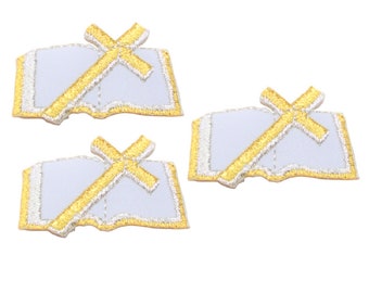 May include: Three embroidered patches featuring a gold cross over a white open book. The edges of the book and cross are outlined in gold. The patches are on a white background.
