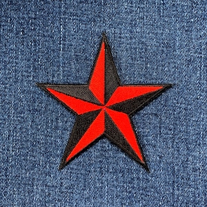 Peut inclure: Un écusson en forme d'étoile nautique rouge et noire. L'étoile est une étoile à cinq branches avec un contour noir et un intérieur rouge. L'étoile est sur un fond en jean bleu.