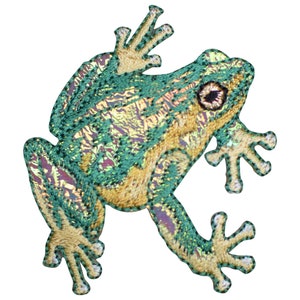 May include: Green and gold embroidered frog patch. The frog is sitting on its hind legs with its front legs raised. The frog has a detailed design with a textured surface.