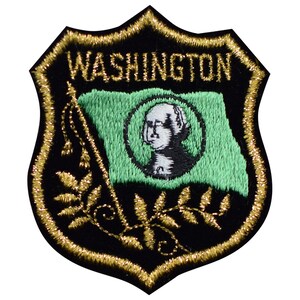 May include: A black and gold embroidered patch featuring the word "WASHINGTON" and a green flag with a portrait of George Washington. The flag is surrounded by a gold wreath.