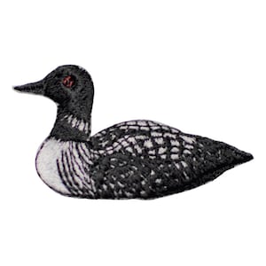 May include: Embroidered patch of a loon, a black and white aquatic bird. The patch features detailed stitching, with a black head and back, and a white breast. The loon has a red eye and a black beak. The patch is likely for clothing or accessories.