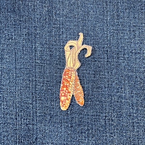 May include: A white ceramic mug with a black handle and the text "But First, Coffee" in a black, handwritten-style font. The mug is on a white surface.